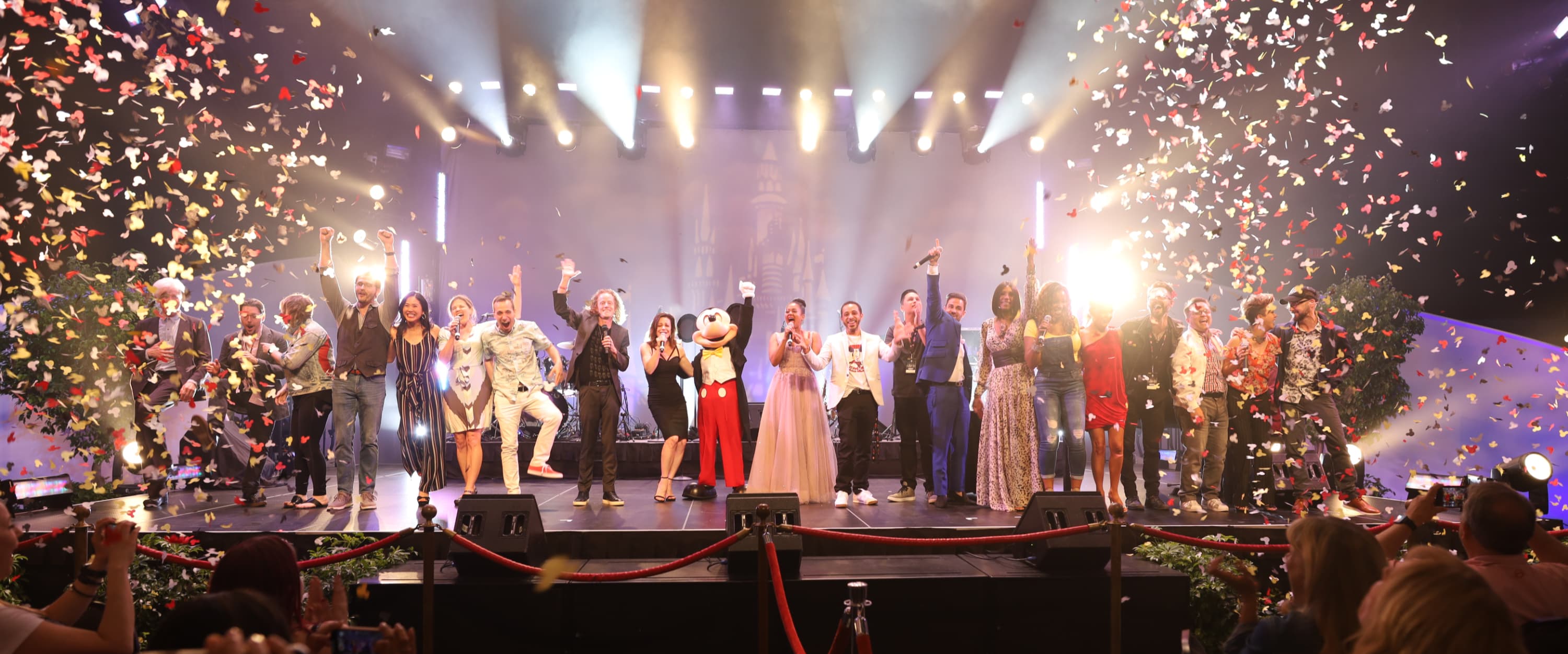 Mouseketeers and Mickey Mouse celebrating with confetti and fists raised in the air