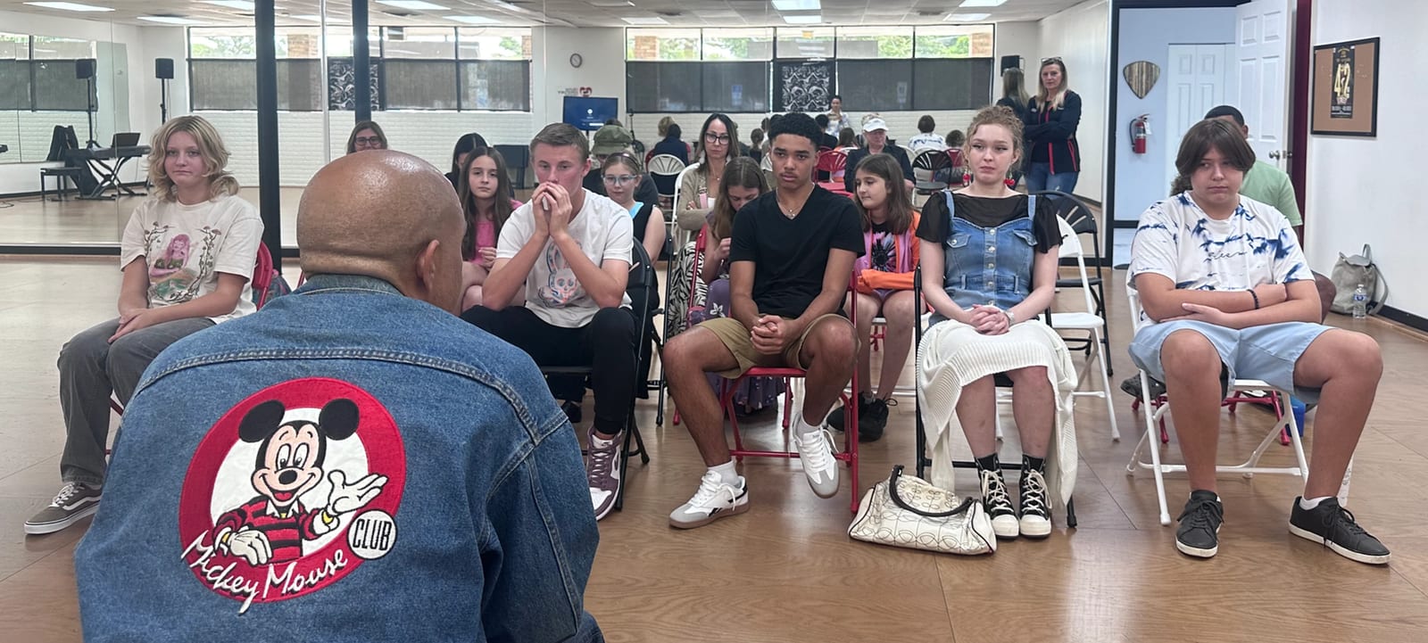A Mouseketeer leading a mentoring session with a room of young performers