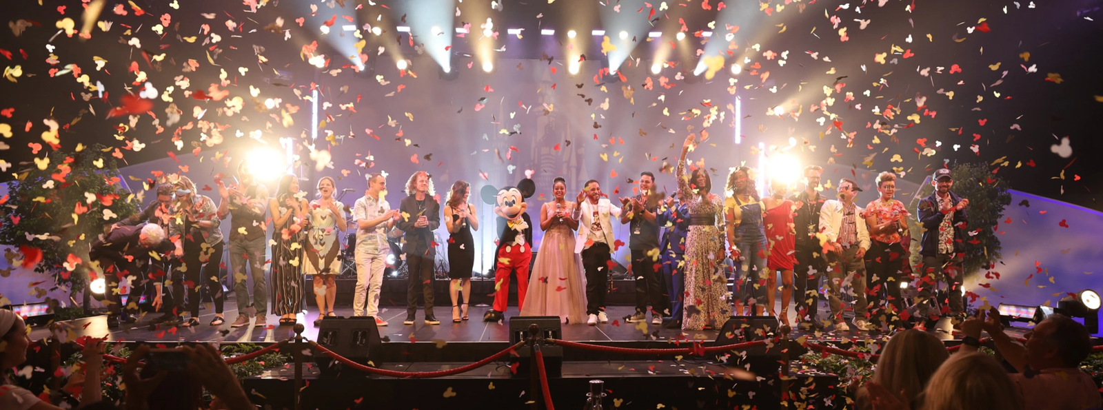 Mouseketeers and Mickey Mouse celebrating amid confetti